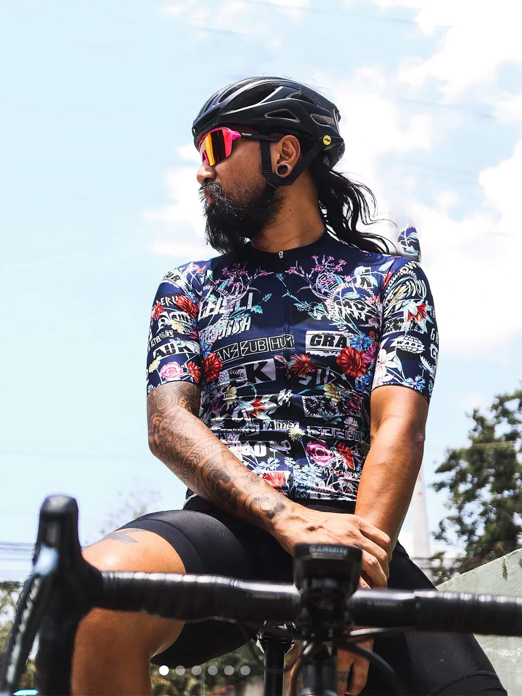 Cyclist wearing Ostroy Punk Flowers Jersey - Men's with punk and floral design in race cut fit against sky background