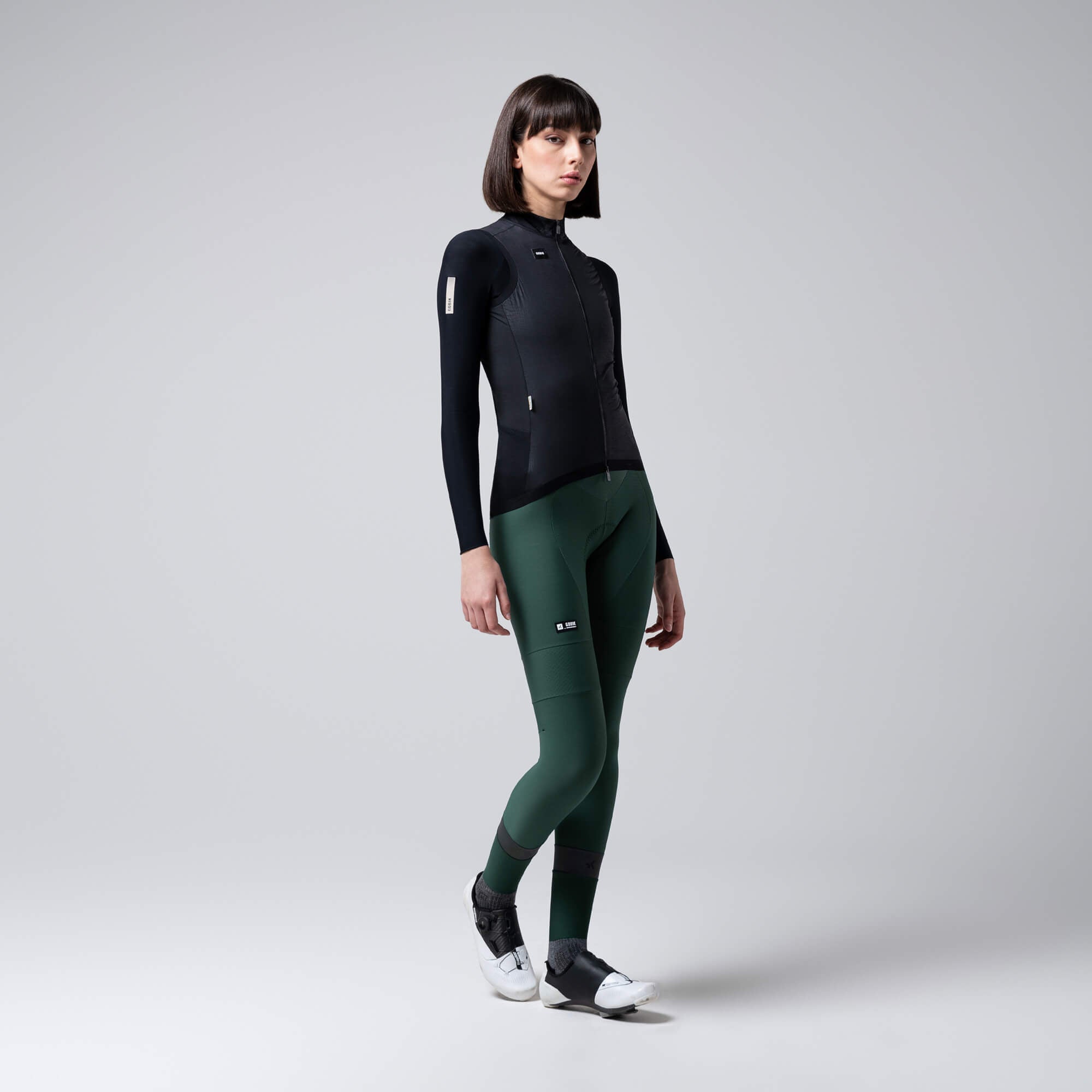 Woman wearing GOBIK Vector 2.0 Vest - Women's in black with slim fit and full front zipper against plain background