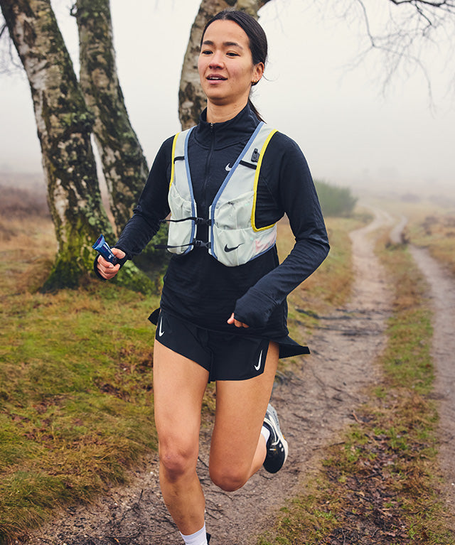 Runner holding Amacx Energy Fruit Chew Cassis on a trail in foggy outdoor setting
