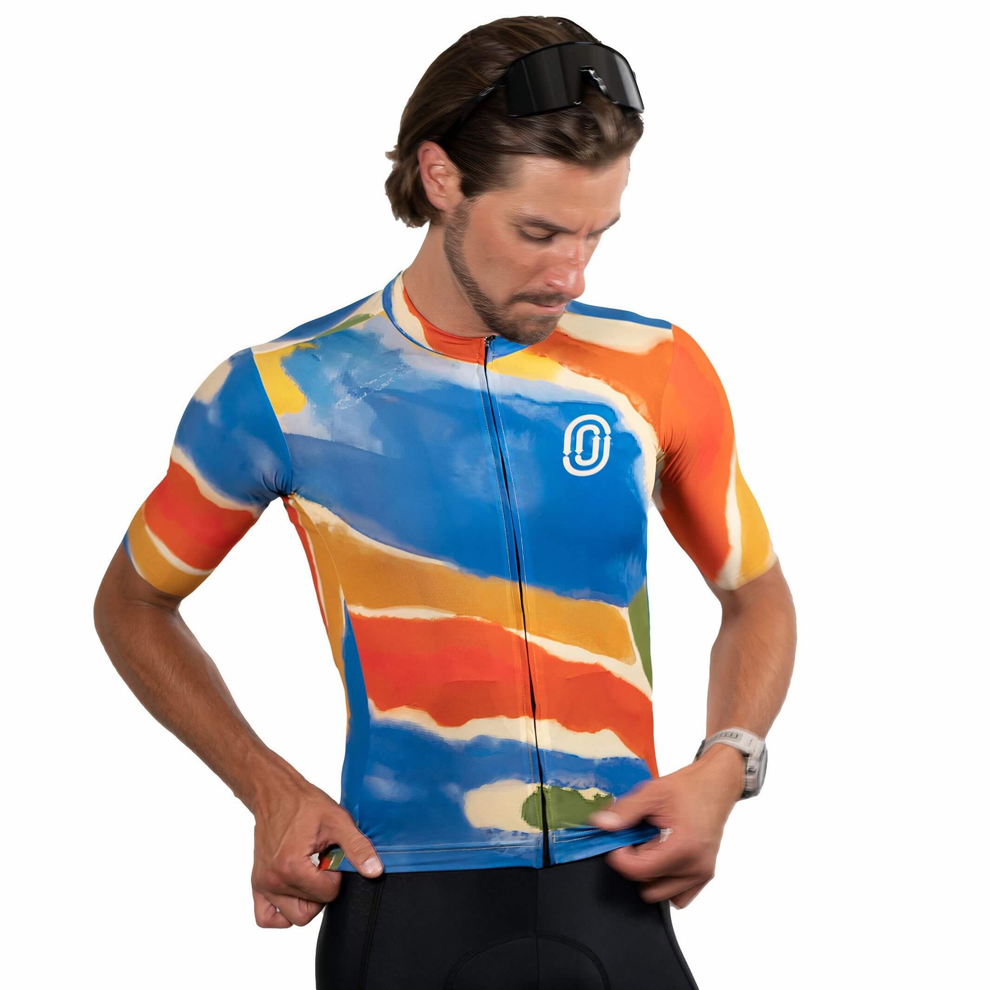 Man adjusting Ostroy Watercolor Jersey - Men's featuring vibrant abstract colors and a slim cycling fit against white background