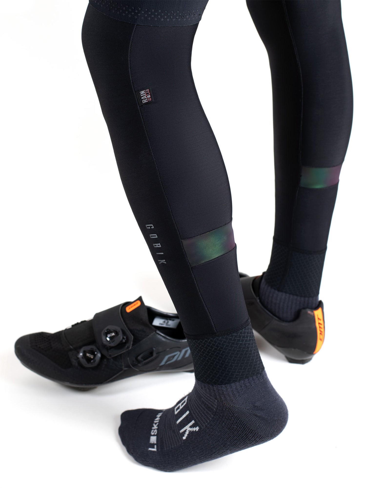 Close-up of a cyclist wearing GOBIK Kaba 2.0 Pitch Thermal Leg Warmers with black cycling shoes and socks.