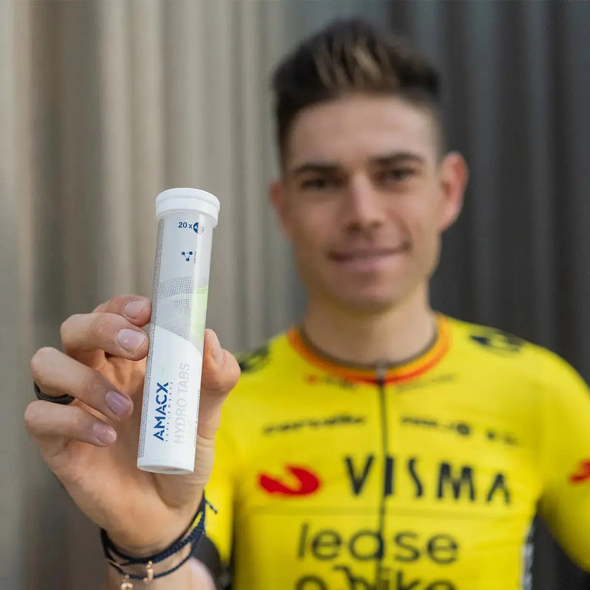 Athlete holding a tube of Amacx Hydro Tabs Lime with focus on the product in hand