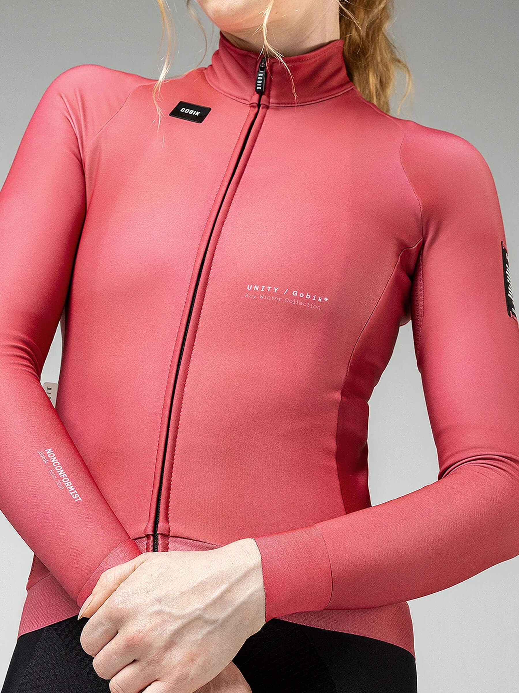 Close-up of woman wearing GOBIK Hyder Long Sleeve Jersey - Women's in pink with full front zipper and elastic cuffs