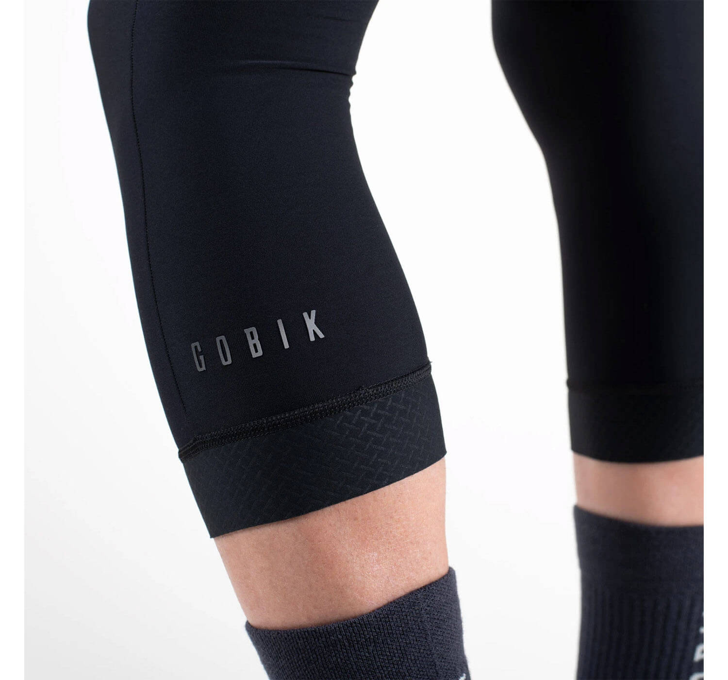 Close-up of GOBIK Haru 2.0 Thermal Knee Warmers - Unisex showing logo and ergonomic cuffs on black fabric